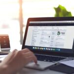 Modern ofis çalışma alanında WordPress kontrol paneli kullanan odaklanmış kişi, notlar ve akıllı telefonla çevrili, verimlilik vurgulu.